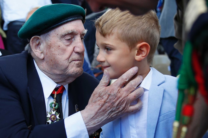 French D-Day veteran Leon Gautier, of the Kieffer commando, cheers a young boy before a D-day ceremony.