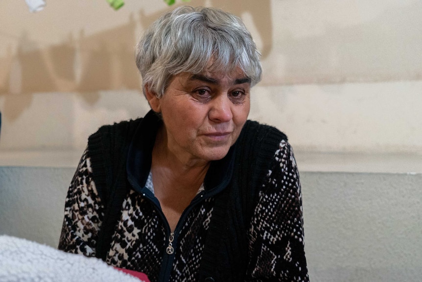 A woman with grey hair and a black top