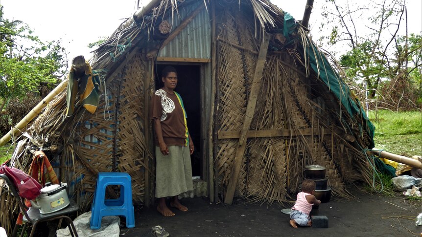Tanna Island resident standing in front of her home on Tanna Island in Vanuatu