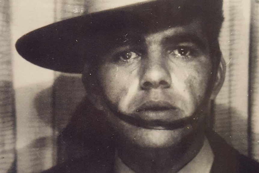 A tight black and white head and shoulders shot of an Indigenous man wearing an Australian Army hat.