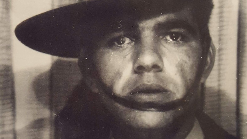 A tight black and white head and shoulders shot of an Indigenous man wearing an Australian Army hat.