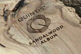 A branch has been sawn in half. The polished side is engraved with the Quintis logo.
