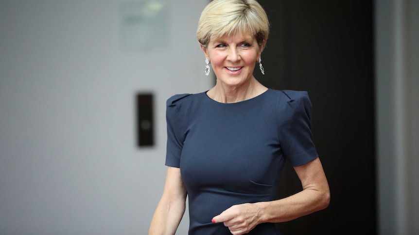 Julie Bishop smiling while walking into the House of Representatives.