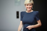 Julie Bishop smiling while walking into the House of Representatives.