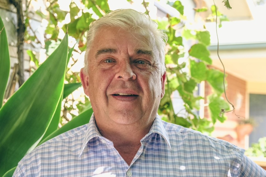 Peter Weaver smiles in front of his garden