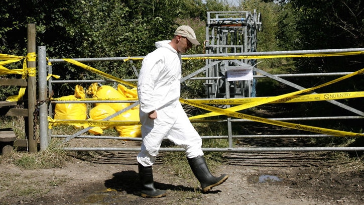 A government official walks past a quarantined farm zone during the 2001 foot and mouth disease outbreak in the United Kingdom.