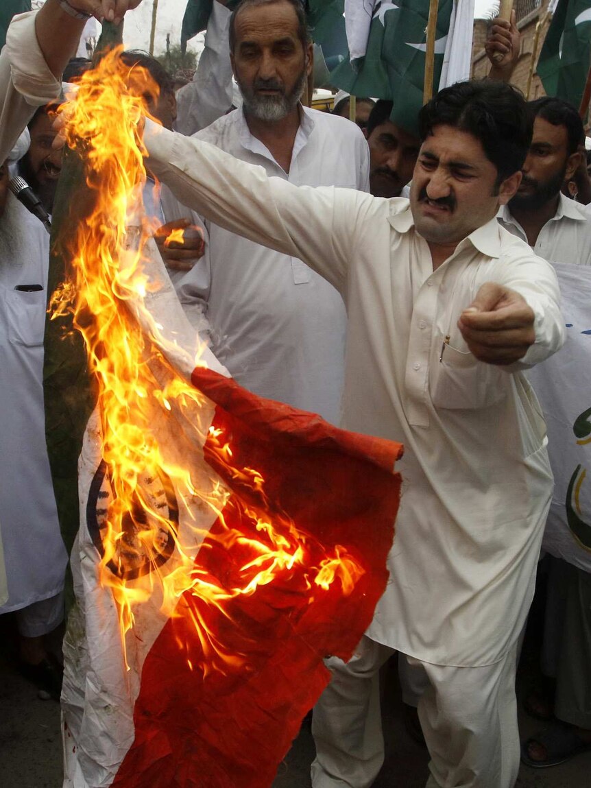 Pakistani protesters burn a representation of an Indian flag in Peshawar.