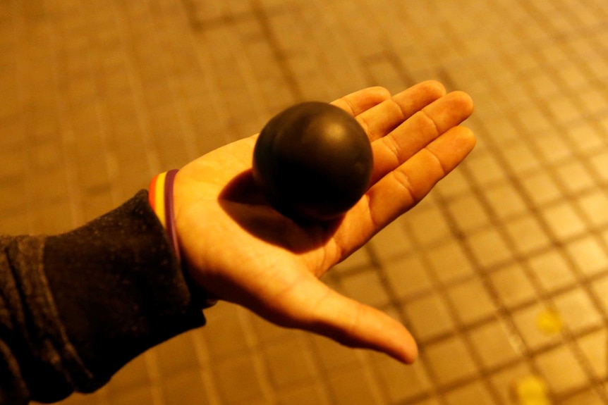 A round rubber ball in the palm of a hand.