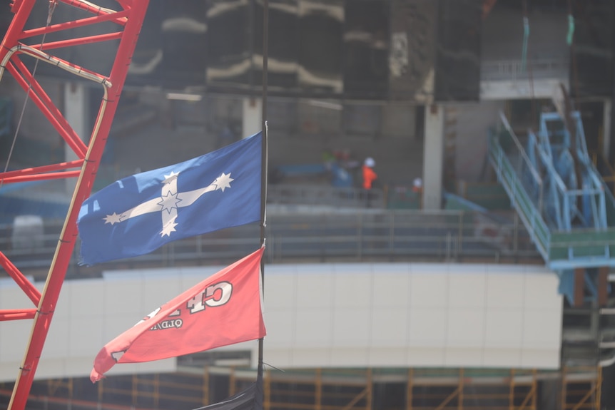 a cfmeu flag flies above a construction site