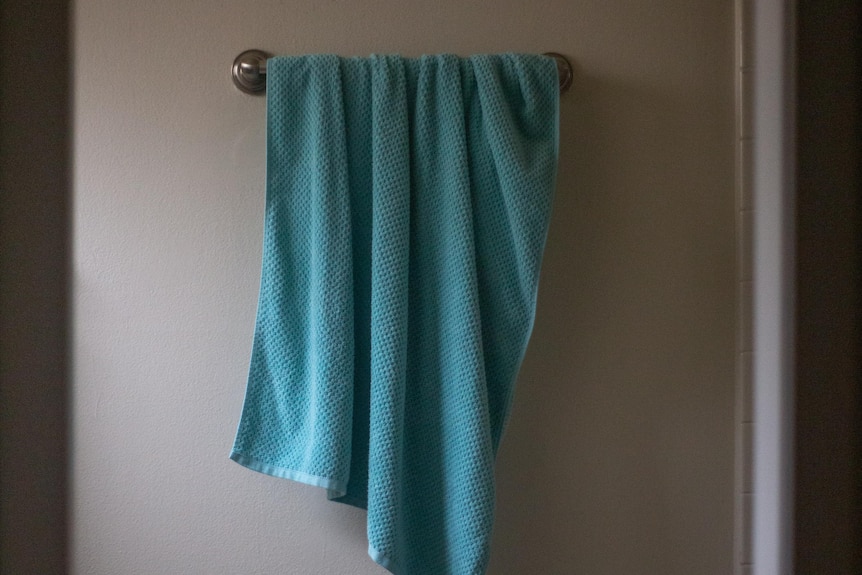 Blue towel hanging up on rail in bathroom
