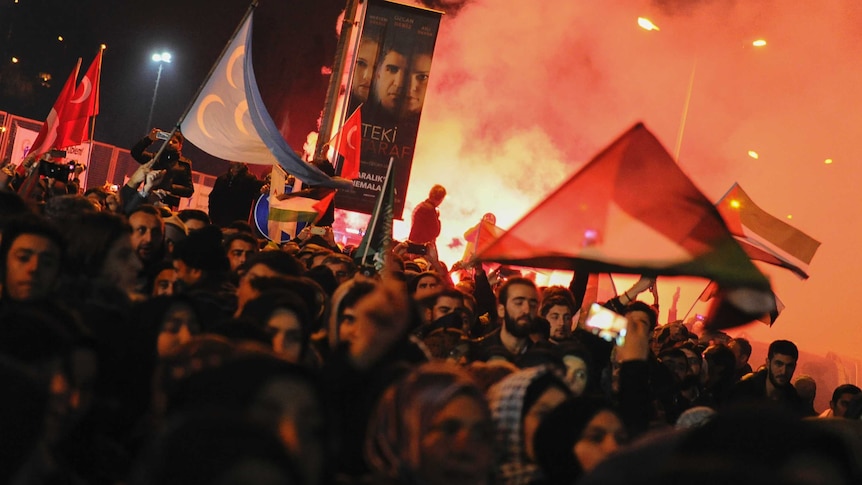Protesters light flares as they participate in a demonstration near the U.S. Consulate in Istanbul