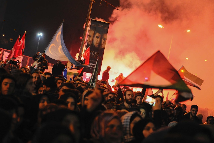 Protesters light flares as they participate in a demonstration near the U.S. Consulate in Istanbul