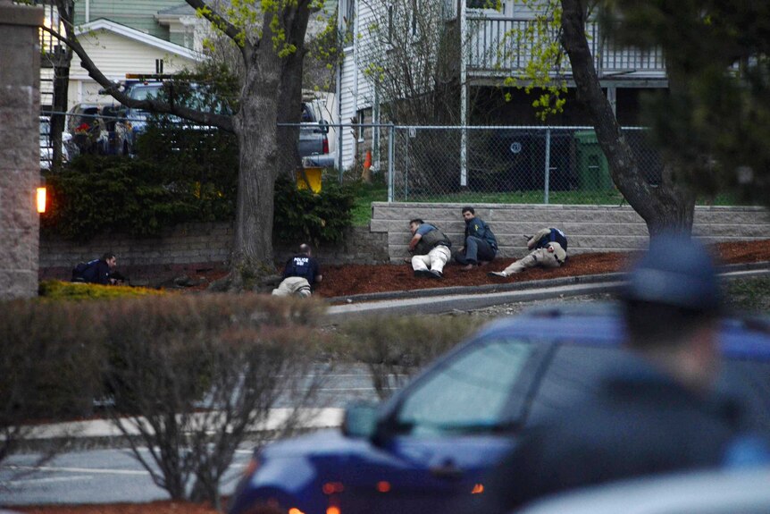 Law enforcement approach an area reportedly where a suspect is hiding on April 19, 2013 in Watertown, Massachusetts