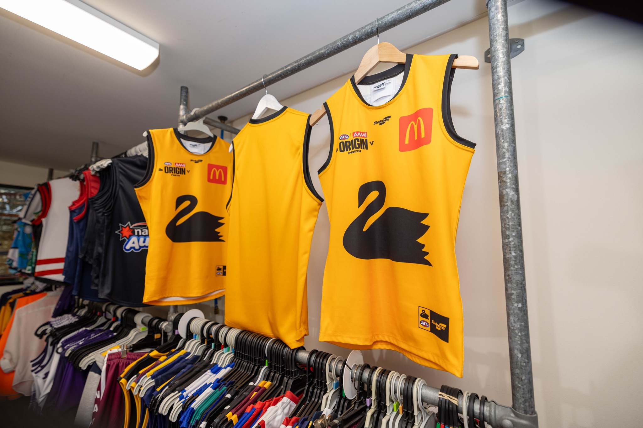 Moletons de futebol amarelos com um cisne negro no meio. 