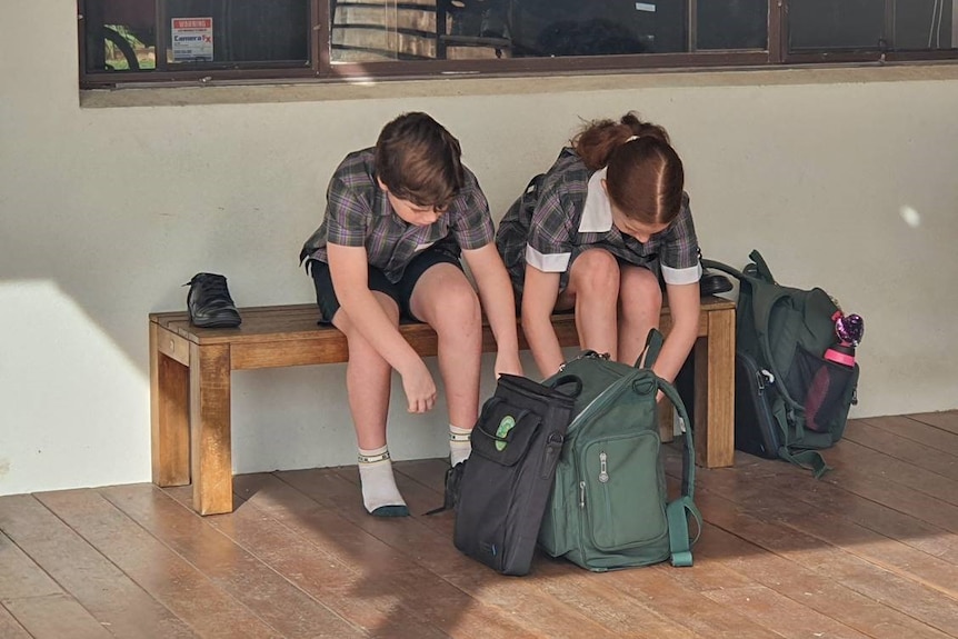 Zara and Lincoln put their school shoes on.