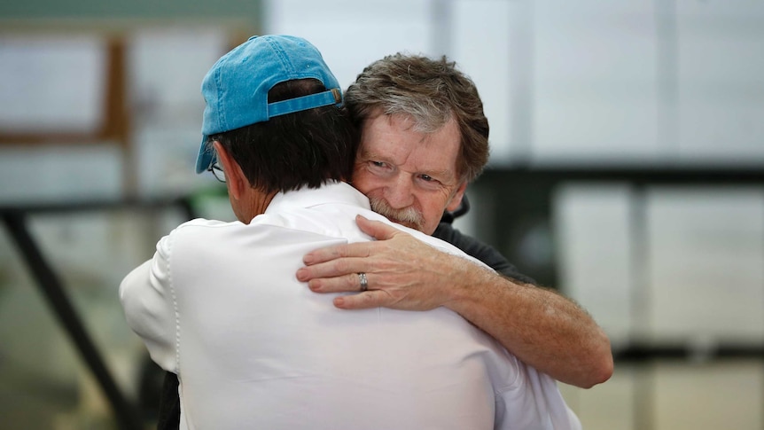 Baker Jack Phillips, owner of Masterpiece Cakeshop, left, is hugged by a man
