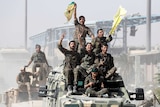 Syrian Democratic Forces (SDF) fighters ride atop military vehicles as they celebrate victory in Raqqa