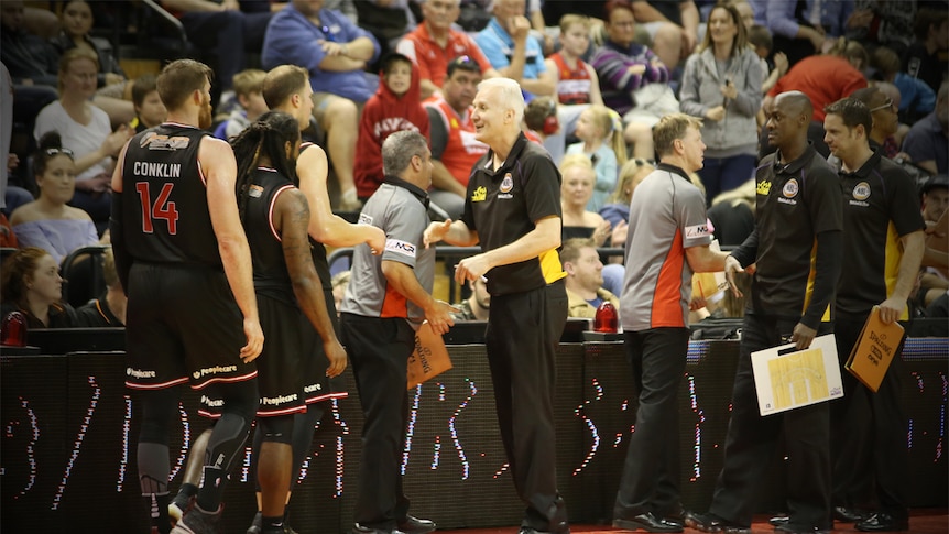 Andrew Gaze shakes hands of Illawarra Hawks players.