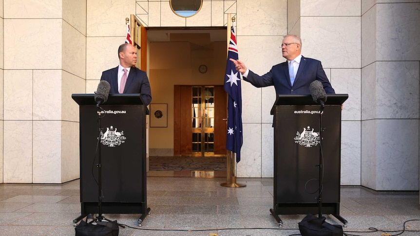 PM Scott Morrison points towards Treasurer Josh Frydenberg at a press conference