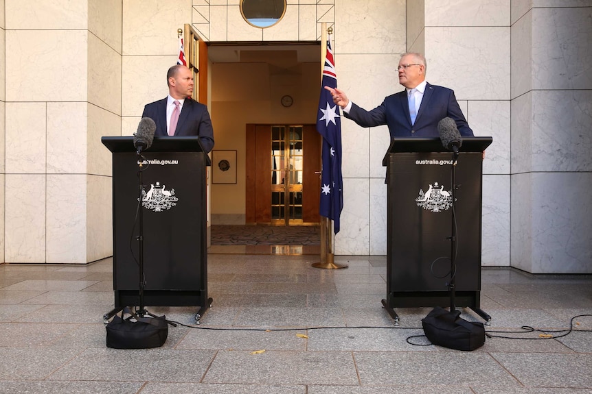 PM Scott Morrison points towards Treasurer Josh Frydenberg at a press conference