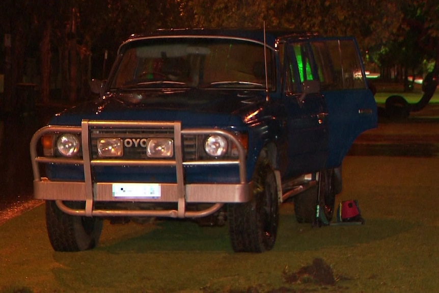 An old blue four-wheel drive on grass