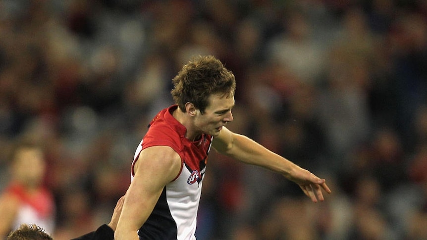 On the brink: Jordan Gysberts kicks under pressure from Leroy Jetta as Melbourne moves to ninth.