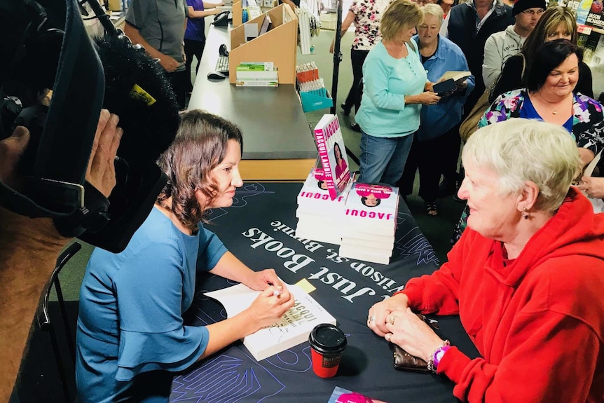Jacqui Lambie signs copies of her autobiography for purchasers.