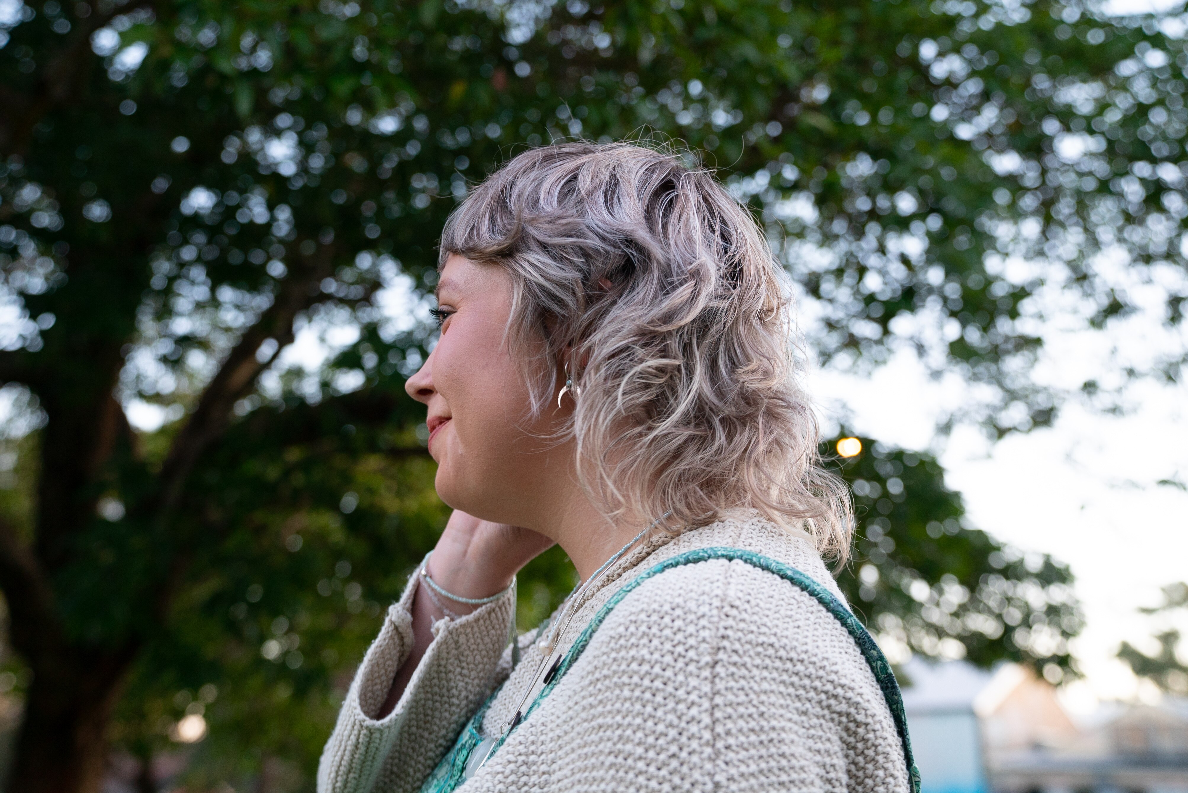 A side shot of a young woman with a blonde mullet. 