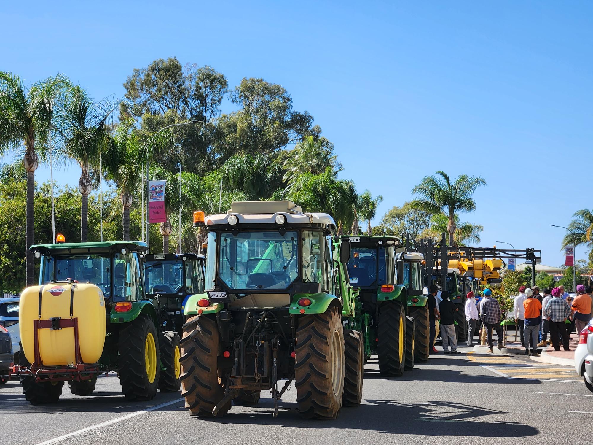 Dozens of tractors, harvesters and trucks lined the street outside the Renmark Hotel on a sunny day.