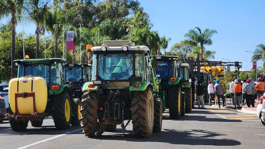 Dozens of tractors, harvesters and trucks lined the street outside the Renmark Hotel on a sunny day.