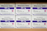 Boxes of a drug labelled 200mg mifepristone tablets sit on a shelf. 