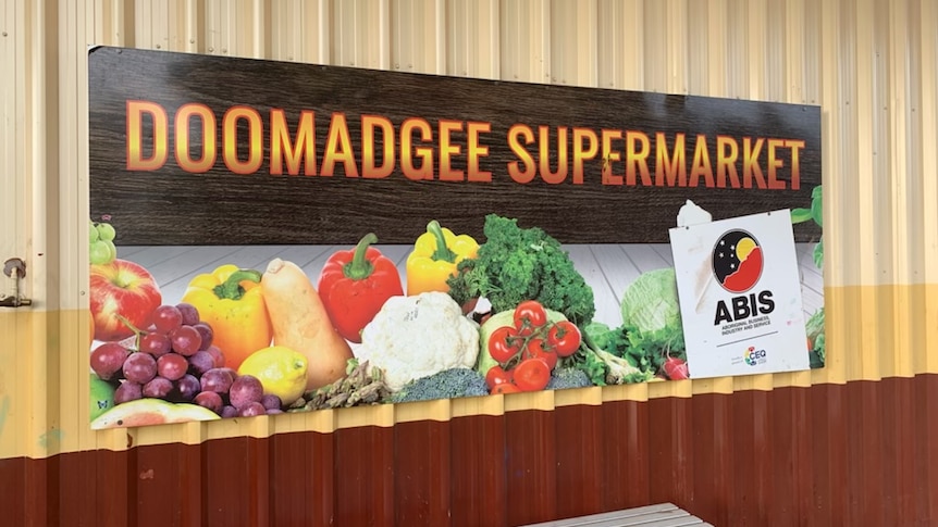 A sign outside a supermarket reading 'Doomadgee supermarket'.