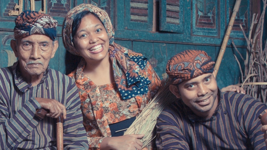 A photo of a couple with father-in-law dressed in traditional Javanese outfits