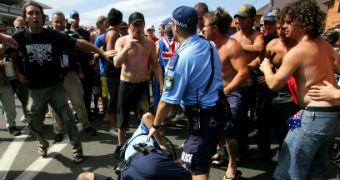 Police Officers hold a man after he made a disturbance at Cronulla beach.