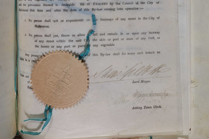 A page from an old book of bylaws with seal attached. Page is signed by the Lord Mayor and Town Clerk.