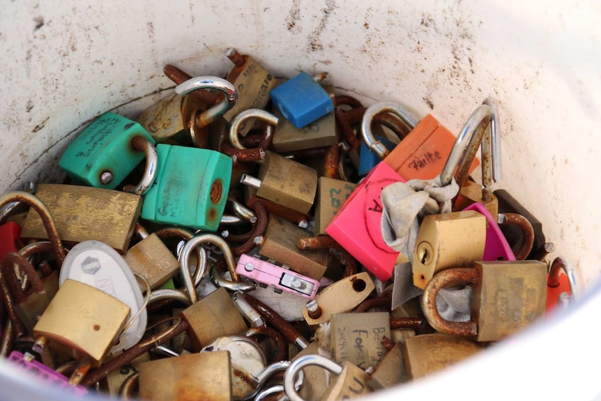 Symbols of love, rusted and destroyed, in a dirty old bucket.