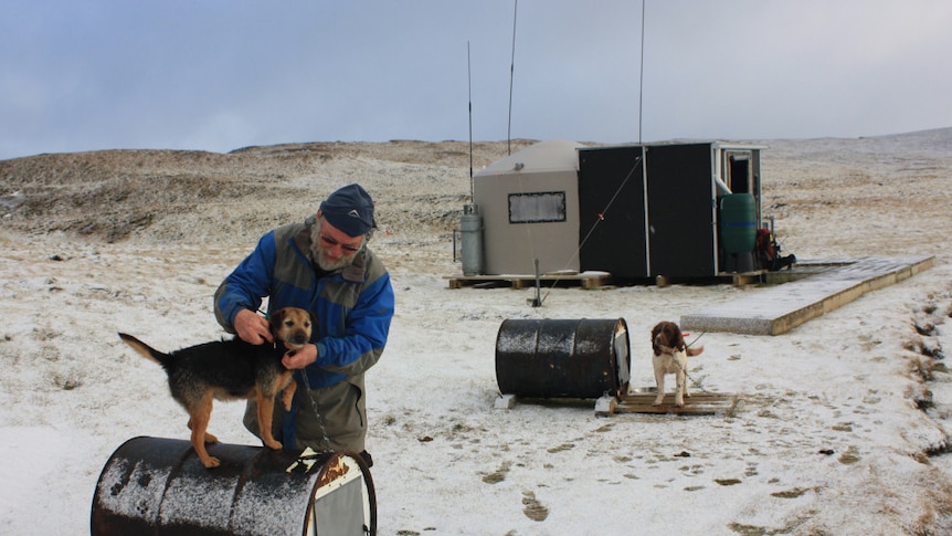 Gary Bowcock with Tama at one of Macquarie Island's water tank field huts