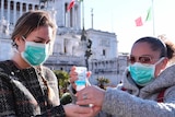 Women wear masks and use hand sanitiser in Rome