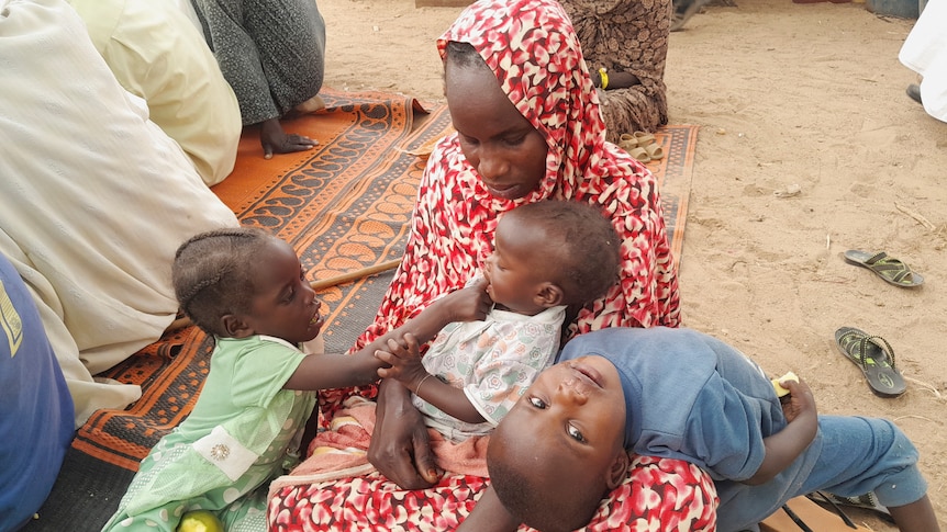 A Sudanese refugee who fled the violence in her country is seen with her children.