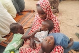 A Sudanese refugee who fled the violence in her country is seen with her children.