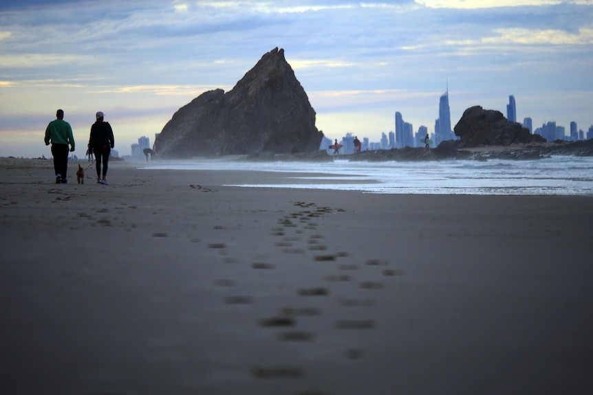 An empty beach with a city in background.