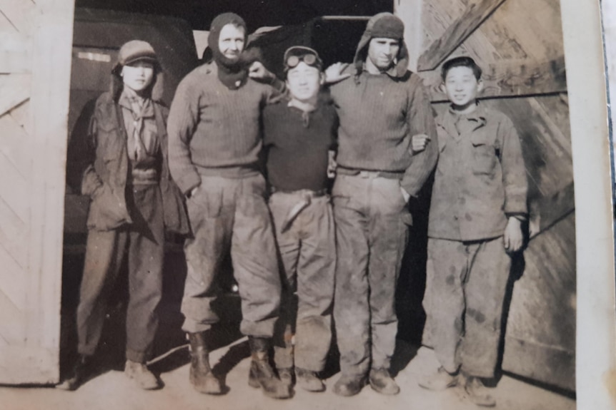 Five men standing in a door way in Korea during the War