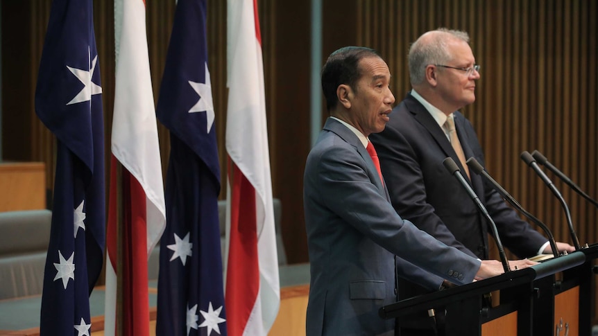 Joko Widodo and Scott Morrison speak in front of Australian and Indonesian flags