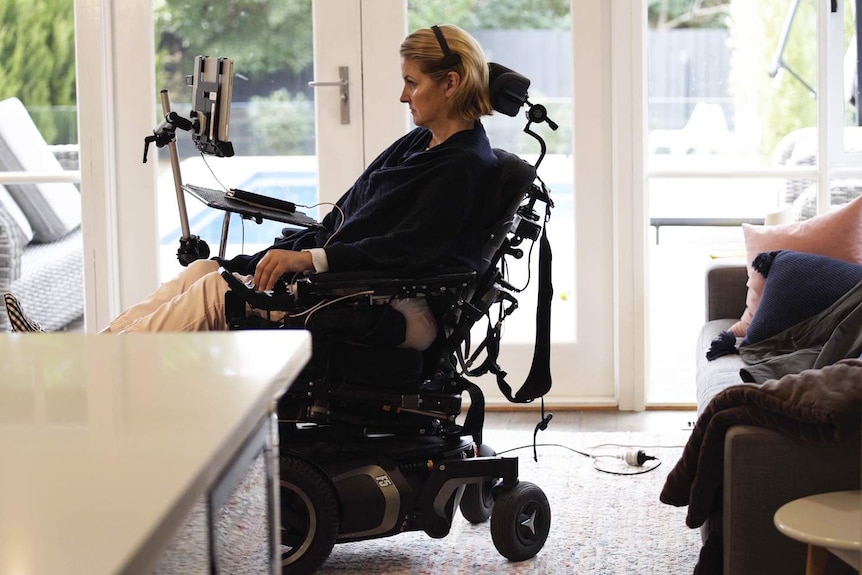 A woman with blonde hair in an electric wheelchair with a head mouse on, showing the experiences of being a disabled parent.