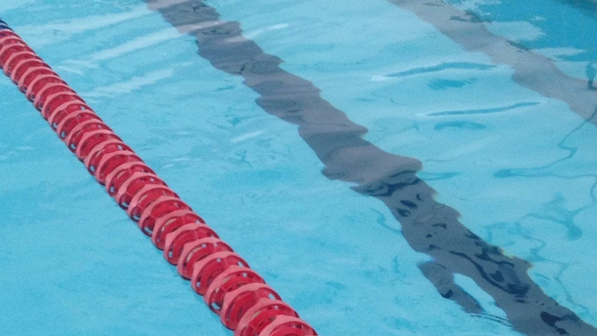 A lane rope floats  in an Olympic-sized swimming pool.