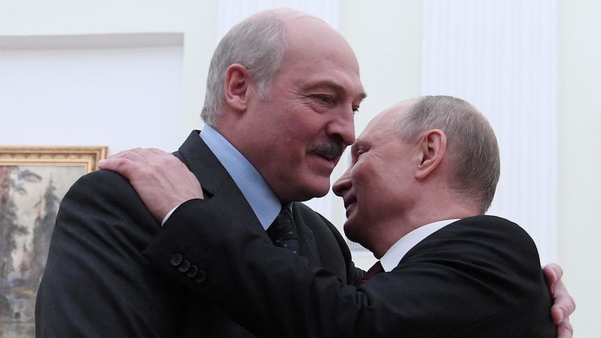 Alexander Lukashenko and Vladimir Putin embrace.