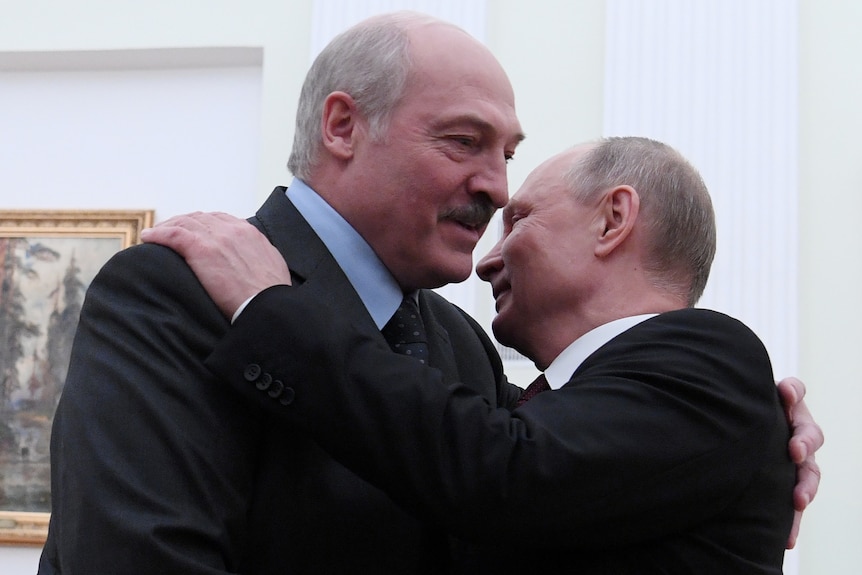 Alexander Lukashenko and Vladimir Putin embrace.