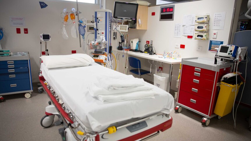 A hospital bed, surrounded by emergency equipment.