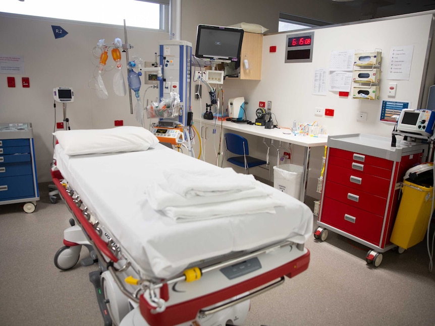 A hospital bed, surrounded by emergency equipment.