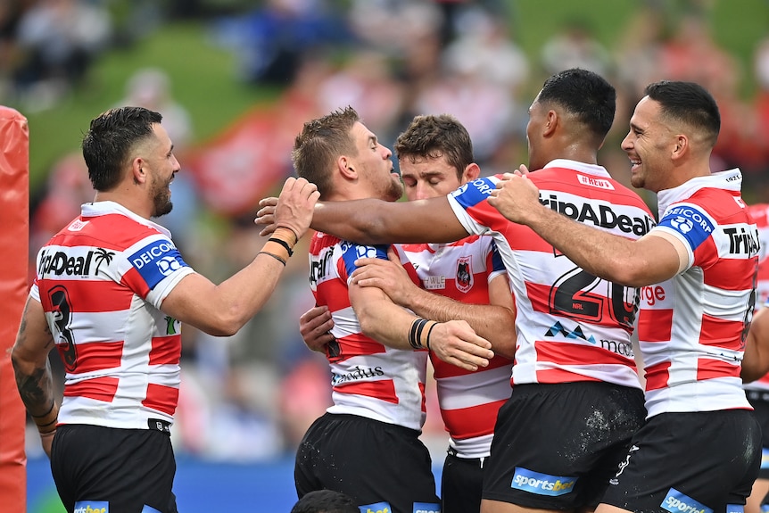 A group of NRL players celebrate after a score.